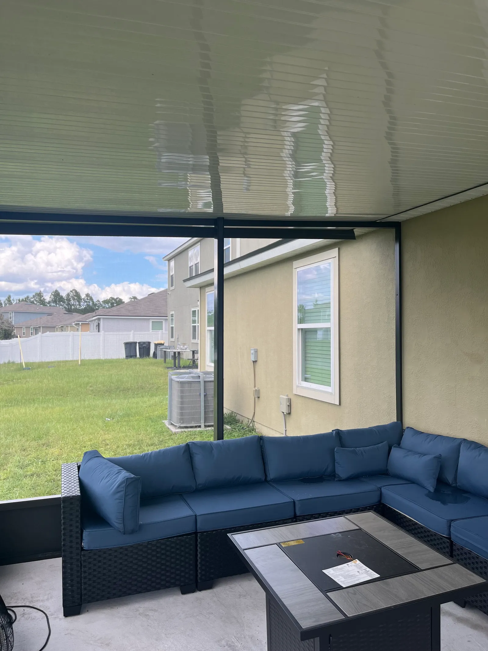 Inside a finished screen room with a sectional and fire table, Greater Jacksonville FL